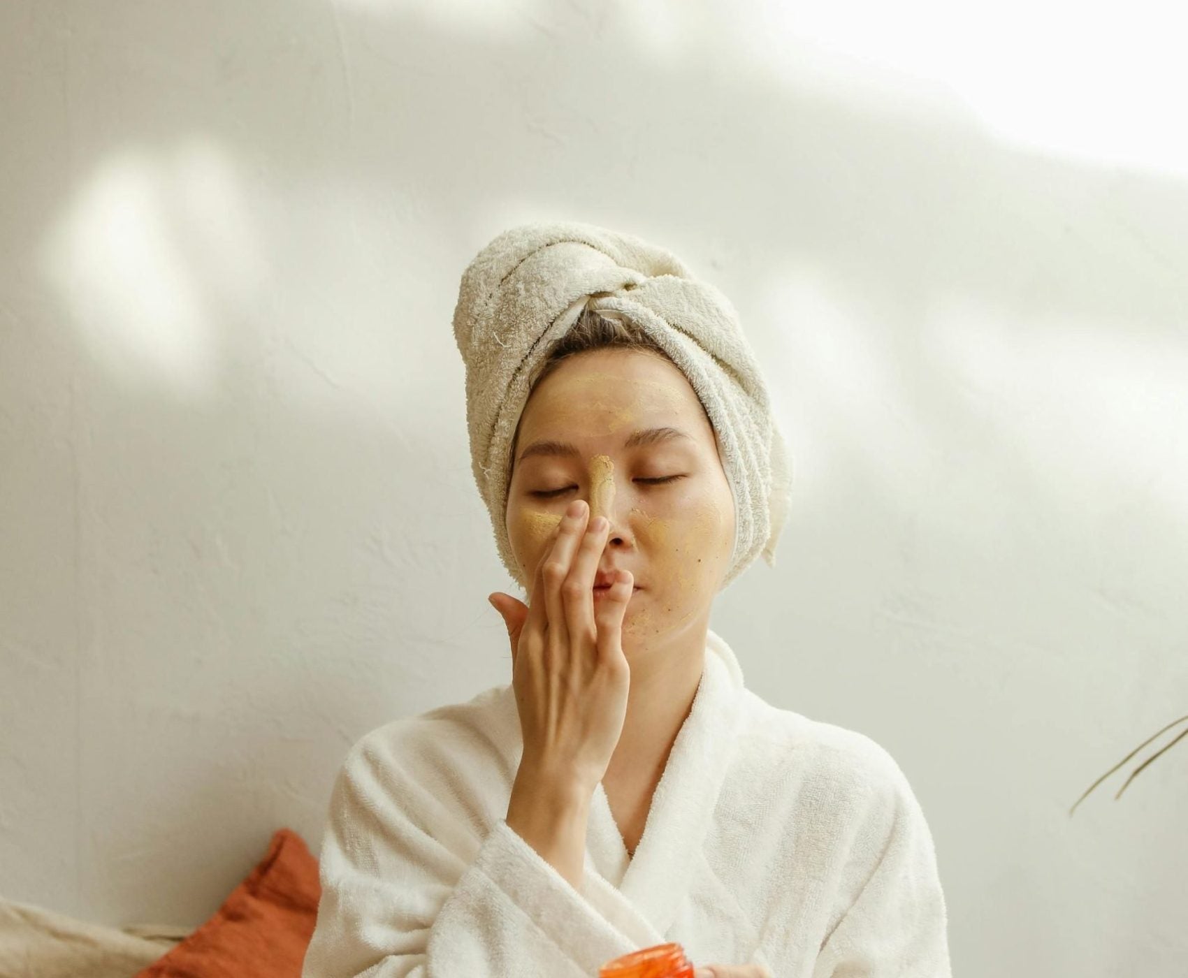 Woman in a towel wrap touching her face